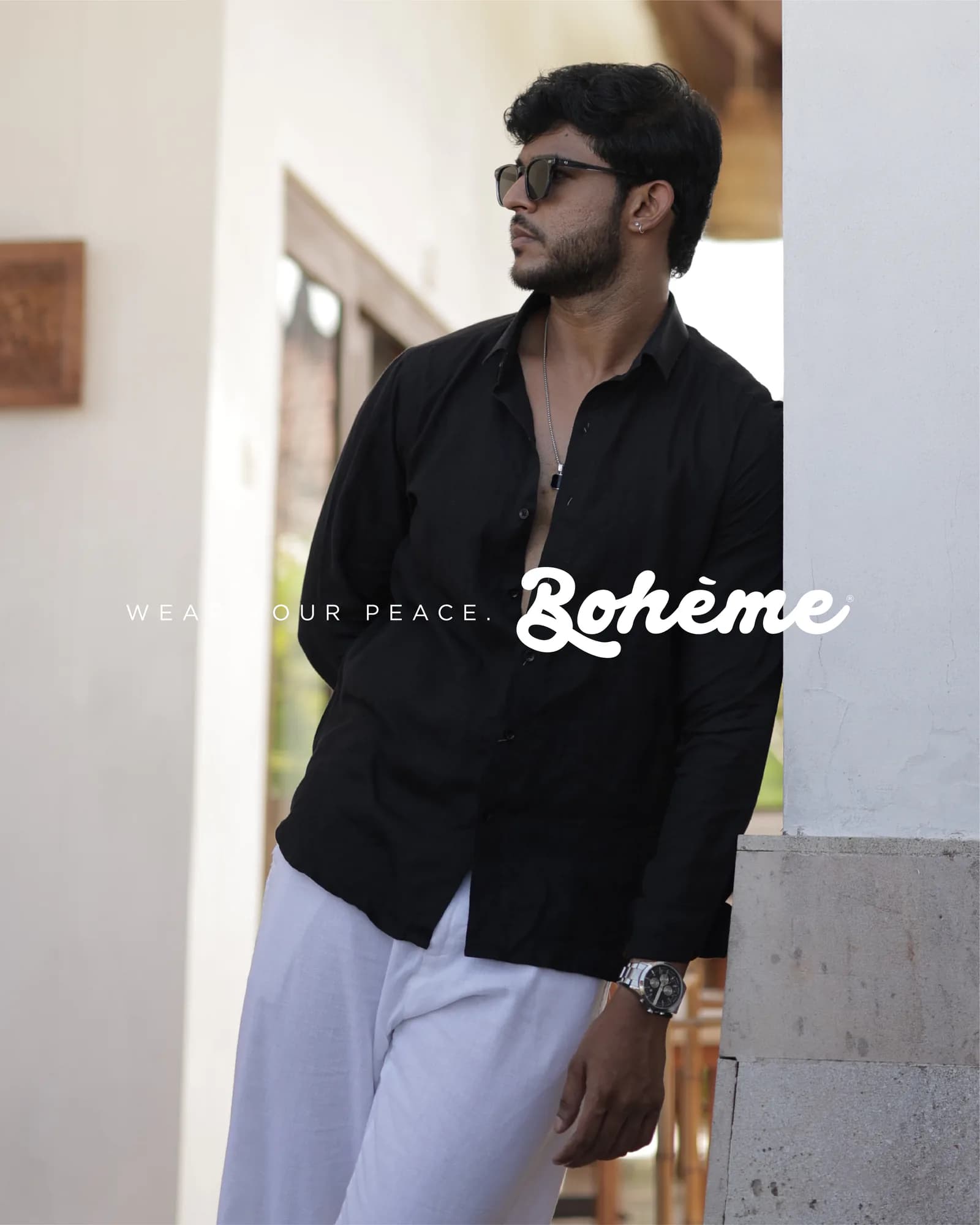 Campaign frame of a model in a black linen shirt beside the Boheme mark